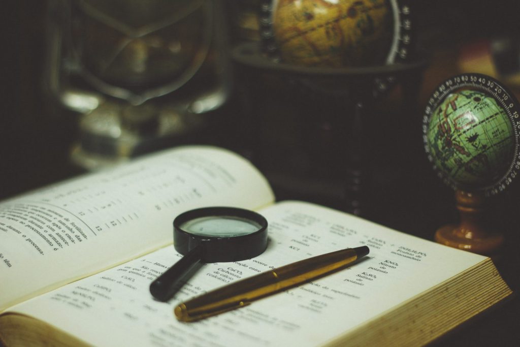 Click pen and magnifying glass on book page.